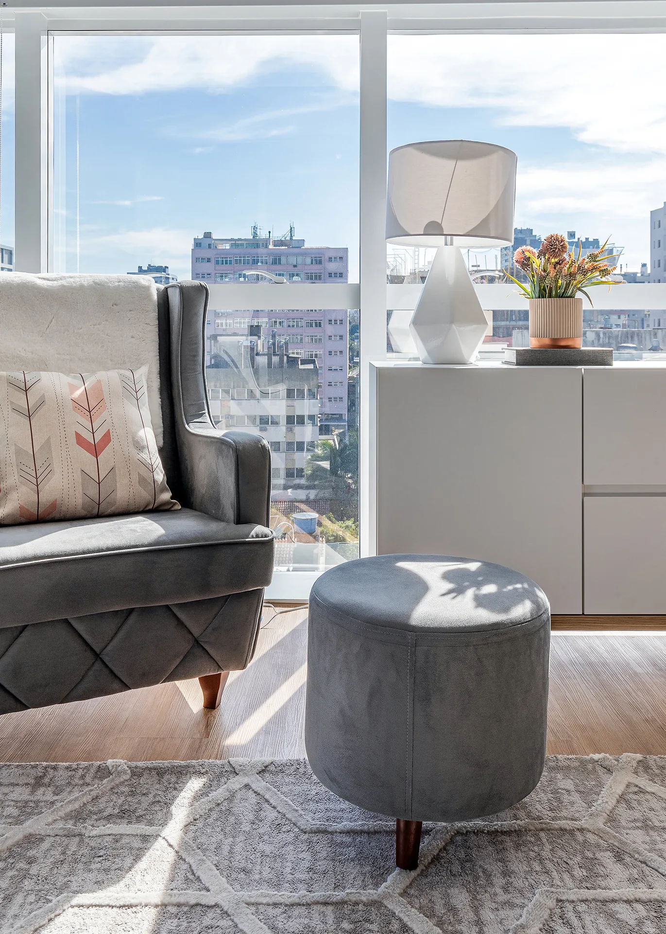 Estar com poltrona, puff e vista da cidade